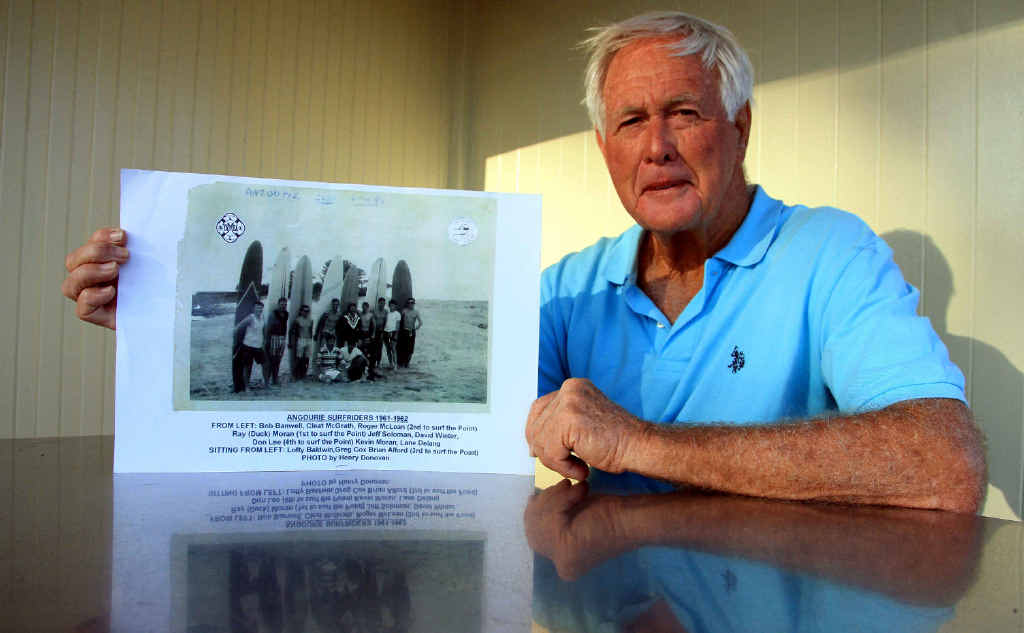 Angourie surfing original Ray Moran with a group photo of the group of Angourie Point originals who will be immortalised on a custom made T-shirt available at the exhibition. Angourie surfing original Ray Moran with a group photo of the group of Angourie Point originals who will be immortalised on a custom made T-shirt available at the exhibition.
